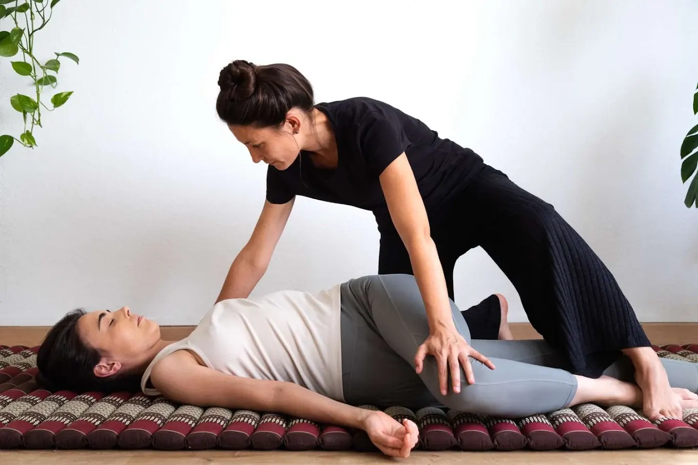 Therapist performing a Thai massage stretch
